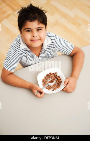 Ragazzo mangiando cioccolato fiocchi di mais Foto Stock