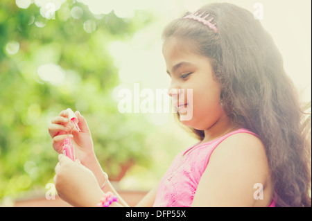 Close-up di una ragazza di applicazione di smalto per unghie su di lei le unghie Foto Stock