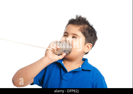 Close-up di un ragazzo che effettua chiamate in un barattolo di latta telefono Foto Stock