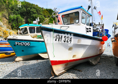 Numeri di registrazione e lettere sullo scafo delle tradizionali barche da pesca ormeggiate sulla spiaggia di ciottoli a Cadgwith Cove, Penisola di Lizard, Cornovaglia, Regno Unito Foto Stock