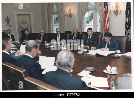 Una fotografia cattura il presidente Ronald Reagan che ha guidato una riunione di gabinetto nel 1985. L'immagine mostra il presidente in discussione con i membri del gabinetto, riflettendo la leadership governativa e i processi decisionali dell'epoca. Foto Stock