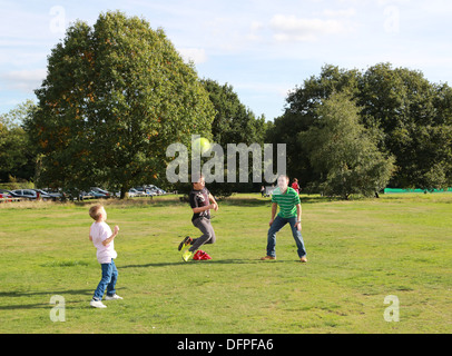 Padre e figli a giocare a calcio nel parco, REGNO UNITO Foto Stock