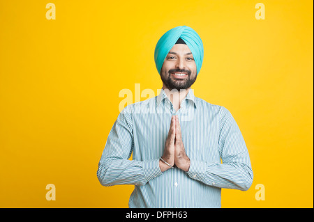 Ritratto di un uomo Sikh saluto con sorriso Foto Stock