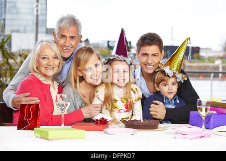 Due fratelli di felice che festeggiano il loro compleanno insieme con la famiglia Foto Stock