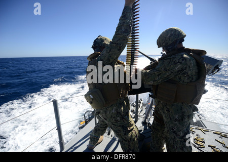 Velisti assegnati alle zone costiere squadrone fluviale (CRS) 2 caricare le munizioni in un azionati a distanza 0,50 Caliber machine gun durante un Foto Stock