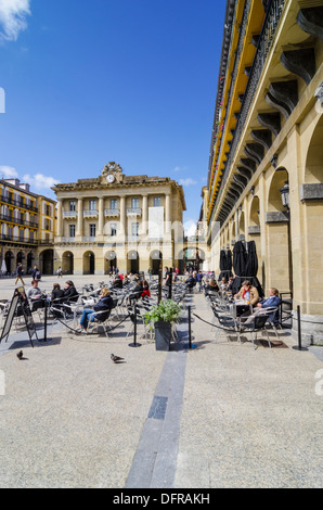 Persone sedute ad un cafe in Plaza de la Constitucion, Parte Vieja, San Sebastian, Spagna Foto Stock