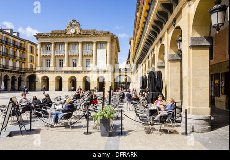 Persone sedute ad un cafe in Plaza de la Constitucion, Parte Vieja, San Sebastian, Spagna Foto Stock