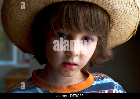 Carino quattro e una metà anno vecchio ragazzo che indossa un cappello di vimini. Foto Stock