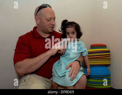 Lt. Cliff Overby, assegnato al comandante, Task Force (CTF) 56, interagisce con un bambino durante una relazione comunitaria dell'evento presso il Foto Stock