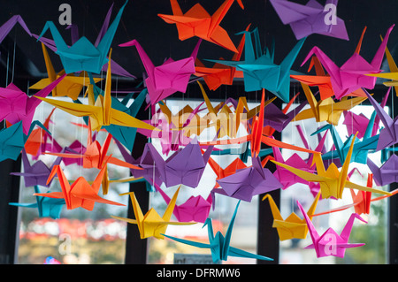 Guerriglia artistica : effimero street art installazione di gru di origami (simboli di pace) su una cabina telefonica a Montreal Foto Stock