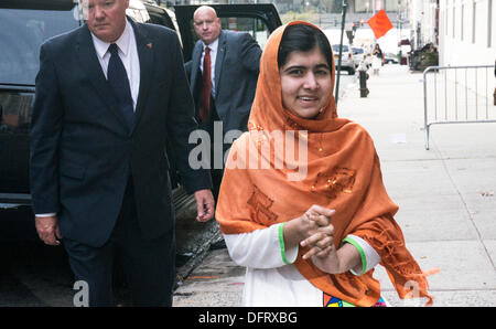 New York, Stati Uniti d'America. 08 ott 2013. Malala Yousafzai schoolgirl pakistano attivista di istruzione delle pause per firmare copie del suo libro, "io sono Malala: La ragazza che si alzò per istruzione e fu ucciso dai talebani", come lei arriva per comparsa sul Daily Show con Jon Stewart. La città di New York, Martedì, 8 ottobre 2013, STATI UNITI D'AMERICA. Credito: Dorothy Alexander/Alamy Live News Foto Stock