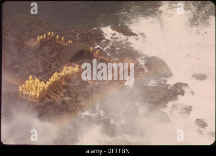 I turisti, vestiti con l'attrezzatura da pioggia gialla, si riuniscono alla Cave-of-the-Winds di Goat Island, una popolare destinazione turistica vicino alle cascate del Niagara, per sperimentare la nebbia e le vedute delle cascate. Foto Stock