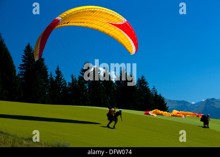 Parapendio in tandem preparando per decollare da una montagna alpina top Foto Stock