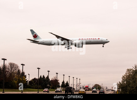 Air Canada Boeing 777 - 300ER 77W con ruote scendendo sorvolano highway road atterraggio all'Aeroporto Pearson di Toronto Foto Stock