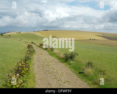 South Downs strada tra Clayton e Ditchling faro su un giorno di estate con due escursionisti in distanza Foto Stock