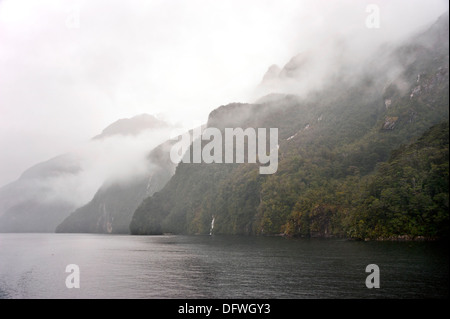Il lago Manapouri nella nebbia e pioggia, il Parco Nazionale di Fiordland, Isola del Sud, Nuova Zelanda Foto Stock