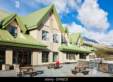 Woman in Red rivestire esternamente il Columbia Icefield Interpretive Center sulla Icefields Parkway Jasper National Park nello stato di Alberta in Canada Foto Stock