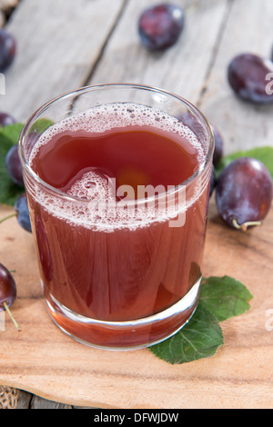 Prugna succo in un bicchiere con frutta fresca Foto Stock