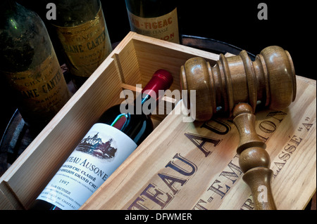 Vendita all'asta di vino raffinato con gavel in caso di vino Chateau Ausone Saint-Émilion e altre vecchie bottiglie di vino Bordeaux fine dietro la Francia Foto Stock