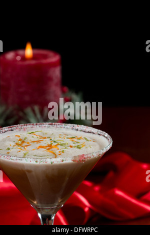 Holiday martini con un cerchio di zucchero e la calce e la scorza di arancia e servite su un tavolo con decorazioni Foto Stock