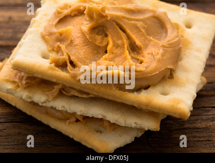 Burro di arachidi sul cracker sul listone spiovente Foto Stock