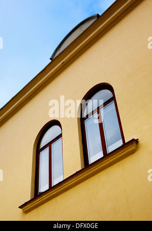 Due finestre ad arco sulla facciata di colore giallo e a basso angolo di visione Foto Stock