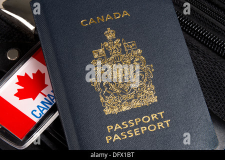 Vista dettagliata del passaporto canadese seduto sulla valigia con Foglia di acero etichetta bagaglio Foto Stock