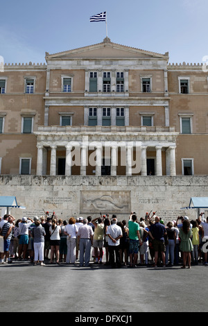 I turisti a guardare la cerimonia del cambio della guardia presso la tomba del milite ignoto di fronte al parlamento greco Foto Stock