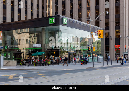 Persone di bere il caffè al di fuori di Starbucks coffee shop in TD Canada Trust Building su cnr di Baia e Queen Street Toronto Foto Stock