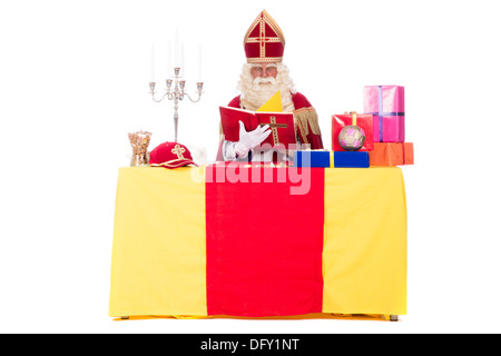 Sinterklaas sta lavorando alla sua scrivania, a sfondo bianco Foto Stock