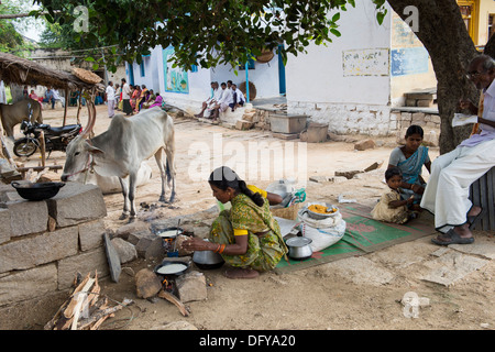 Donna indiana che dosa di cottura per la gente per strada in una zona rurale villaggio indiano. Andhra Pradesh, India Foto Stock