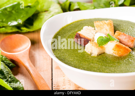 Il fuoco selettivo sulla crosta secca in Crema di zuppa di spinaci Foto Stock