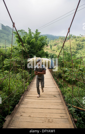 Nero villaggio hmong uomo portare la roba, Catcat, Sa Pa, Lao Cai, Vietnam Foto Stock