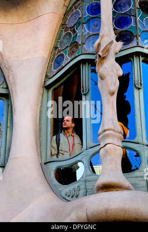 Barcellona, in Catalogna, Spagna. Casa Batllo (Antoni Gaudi; 1904-06) Passeig de Gracia. Dettaglio della facciata. Uomo che guarda fuori della finestra Foto Stock