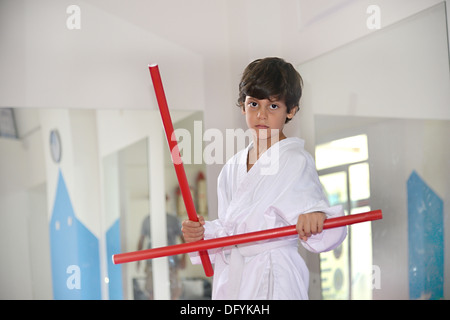 Arti marziali boy tenendo due bastoni rosso denominato ka-li - bastoncini di combattimento Foto Stock