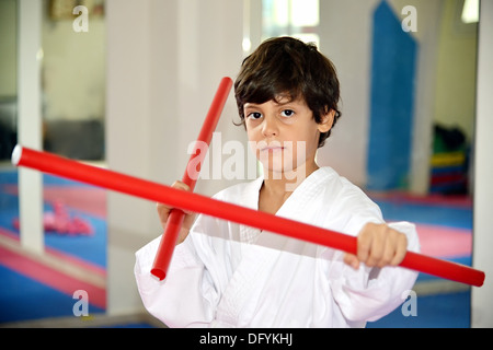 Arti marziali boy tenendo due bastoni rosso denominato ka-li - bastoncini di combattimento Foto Stock