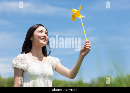 Giovane donna con il mulino a vento di giocattolo Foto Stock