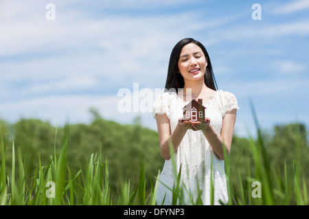 Giovane donna con toy house Foto Stock