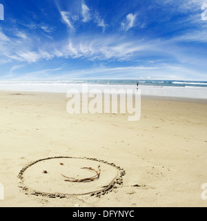 Faccia realizzata sulla sabbia in spiaggia Foto Stock