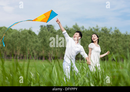 Coppia giovane aquilone volante all'aperto Foto Stock