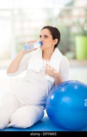 Bella donna incinta di bere acqua fresca dopo allenamento Foto Stock