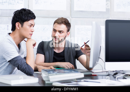 I giovani adulti discutendo in ufficio Foto Stock