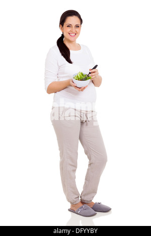 Felice donna incinta sulla dieta mangiare insalata fresca su sfondo bianco Foto Stock