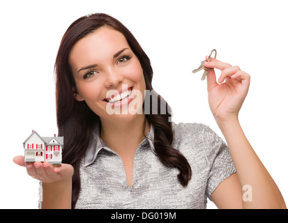 Razza mista femmina presentando le chiavi di casa tenendo una piccola casa isolata su sfondo bianco. Foto Stock