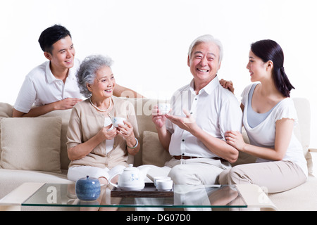 La famiglia felice avente il tè e in chat Foto Stock