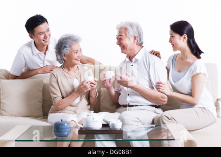 La famiglia felice avente il tè e in chat Foto Stock