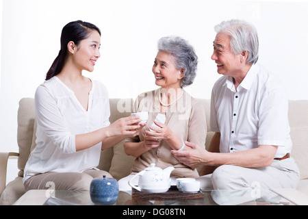 La famiglia felice avente il tè e in chat Foto Stock