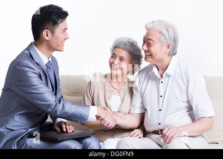 Coppia senior stringono le mani con il consulente finanziario Foto Stock