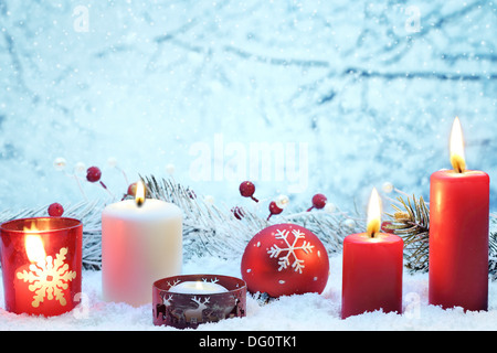 Decorazione di Natale con le candele e la sfera sulla neve. Foto Stock