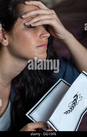 Ritratto di pianto giovane donna holding necrologio Foto Stock